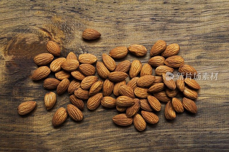 Pile of almonds on rustic pine wood table